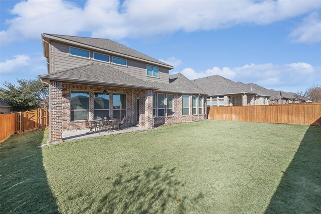 back of property with a lawn and a patio