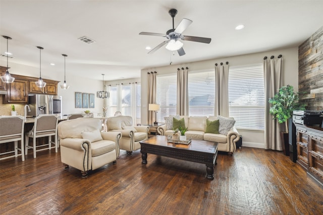 living room featuring dark hardwood / wood-style flooring, ceiling fan, and a healthy amount of sunlight