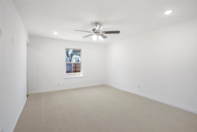 unfurnished room with light colored carpet and ceiling fan