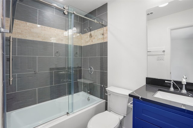 full bathroom featuring toilet, bath / shower combo with glass door, and vanity