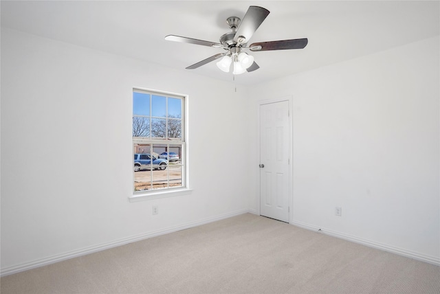 carpeted spare room featuring ceiling fan