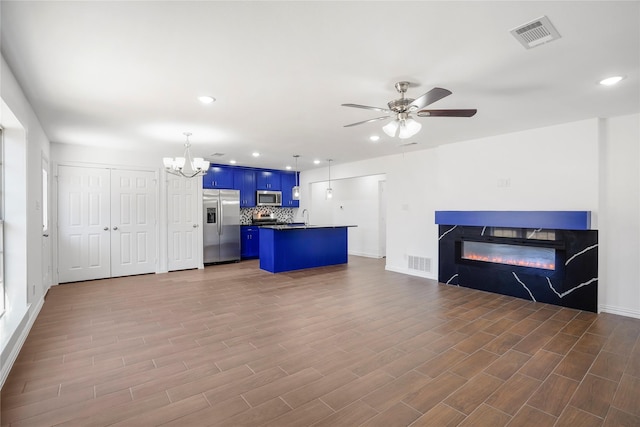 kitchen with a breakfast bar area, stainless steel appliances, a center island, decorative backsplash, and blue cabinets