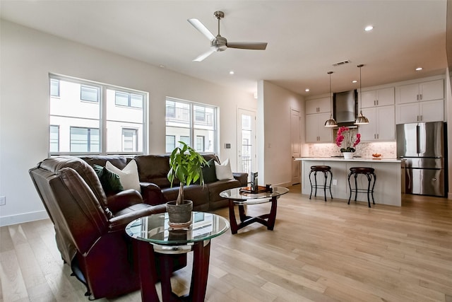 living room featuring ceiling fan and light wood-type flooring