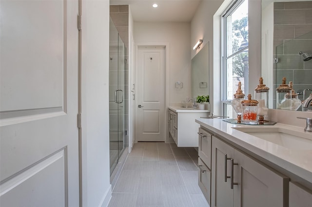 bathroom featuring vanity, a shower with shower door, and tile patterned floors