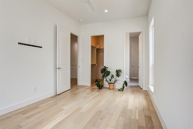 bedroom featuring a walk in closet, ensuite bath, light hardwood / wood-style floors, and a closet