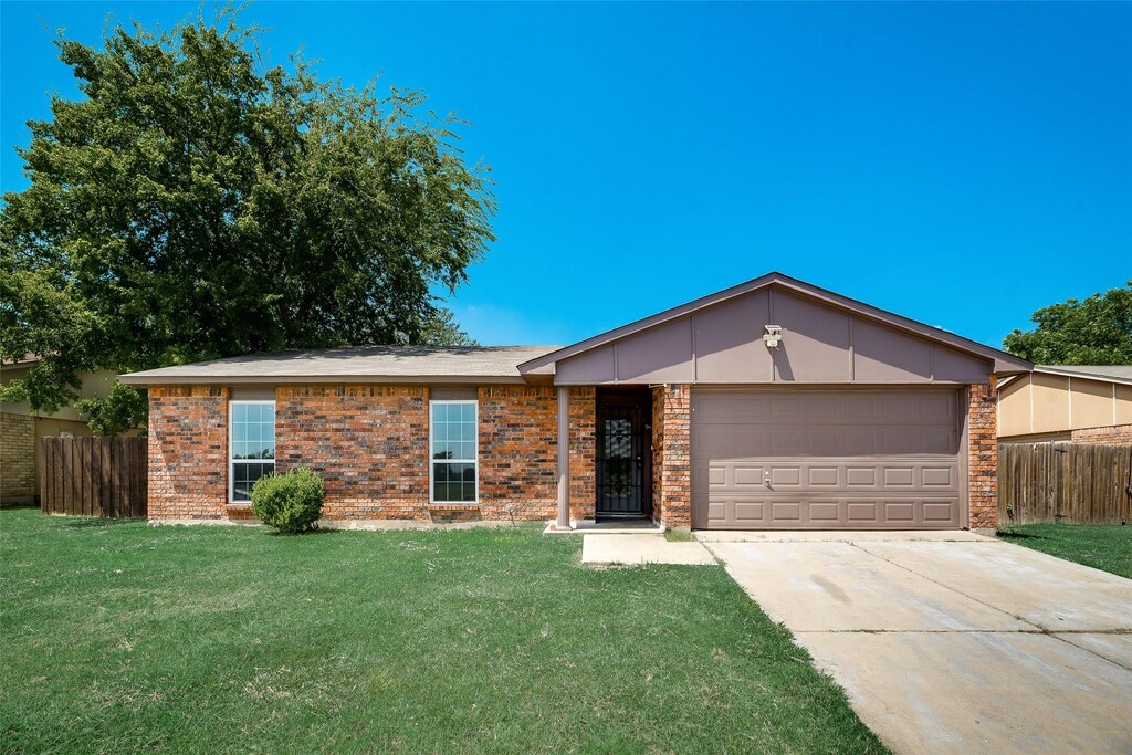 ranch-style house with a garage and a front yard