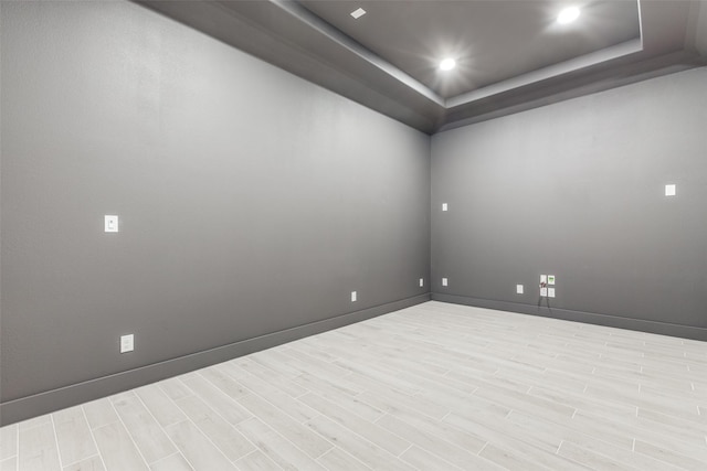 empty room featuring light hardwood / wood-style flooring and a raised ceiling