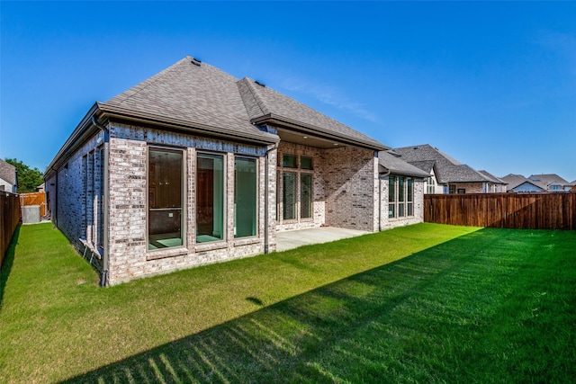 back of house featuring a yard and a patio area