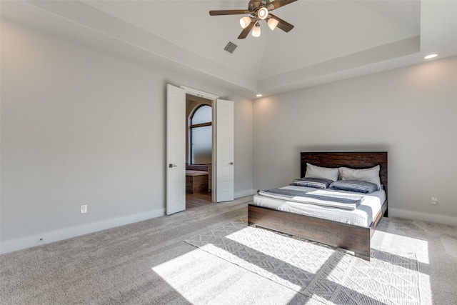 carpeted bedroom with lofted ceiling, ensuite bath, and a tray ceiling