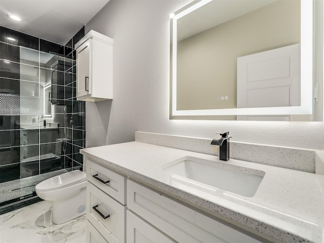 bathroom featuring tiled shower, vanity, and toilet