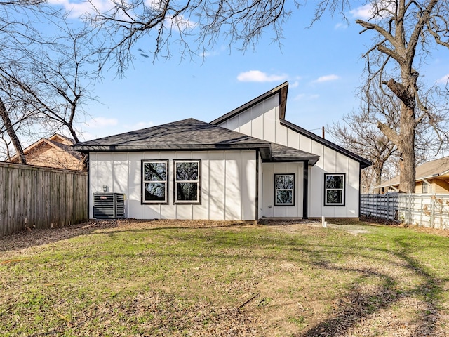 rear view of house with a lawn and cooling unit