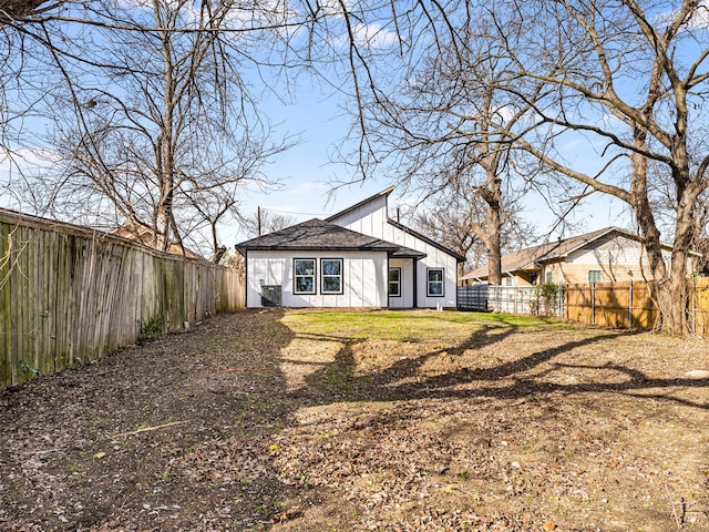 rear view of property with a lawn and central AC