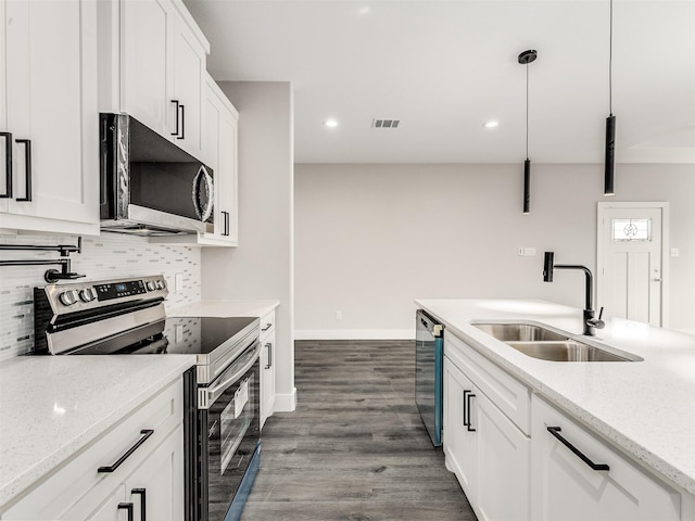 kitchen featuring light stone countertops, white cabinetry, sink, pendant lighting, and appliances with stainless steel finishes