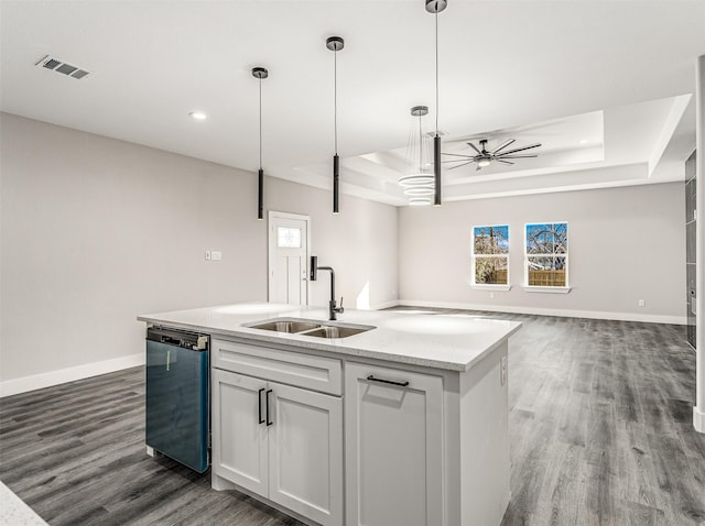 kitchen with stainless steel dishwasher, a raised ceiling, white cabinetry, and sink