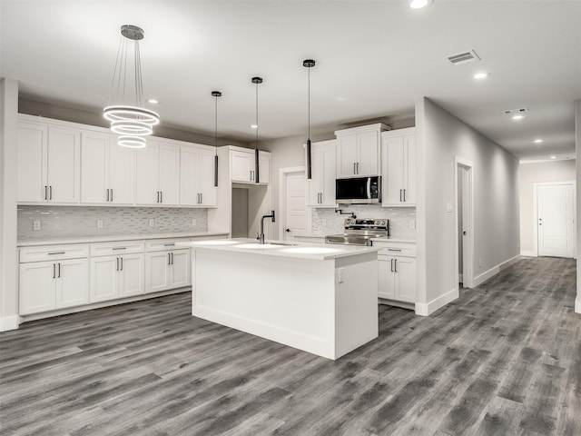 kitchen with stainless steel appliances, white cabinetry, and hanging light fixtures