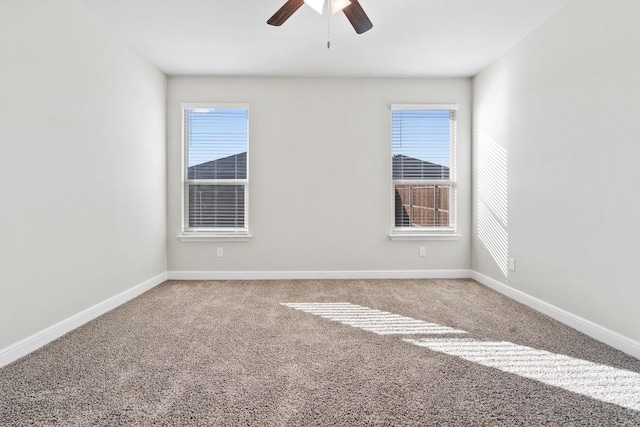 unfurnished room with ceiling fan and carpet