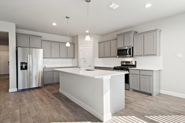 kitchen featuring appliances with stainless steel finishes, tasteful backsplash, light hardwood / wood-style floors, and sink