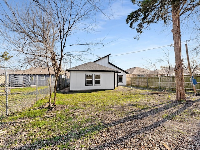 rear view of house featuring a lawn