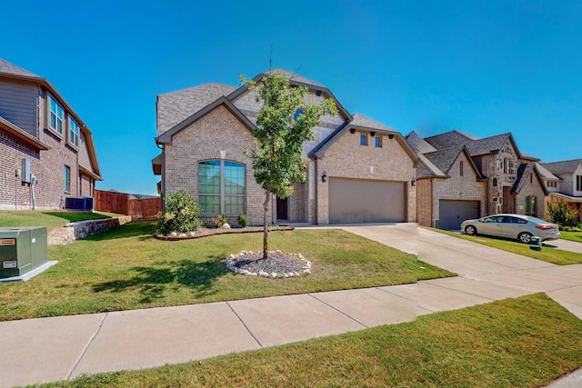 view of front of home featuring a front yard, central AC, and a garage