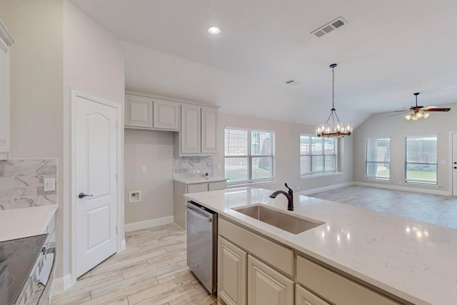 kitchen featuring pendant lighting, backsplash, sink, vaulted ceiling, and stainless steel dishwasher