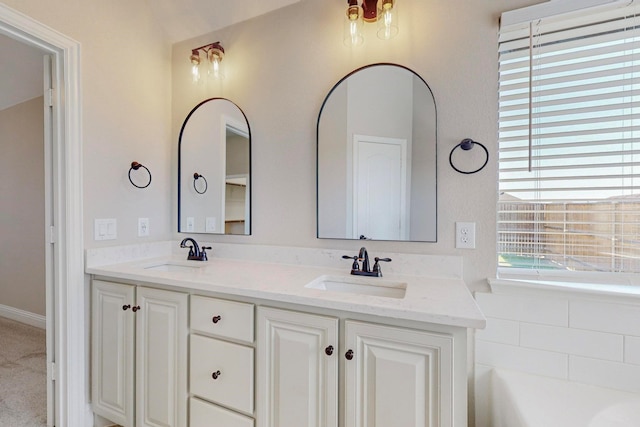 bathroom featuring vanity and a bath