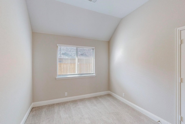 carpeted empty room with lofted ceiling