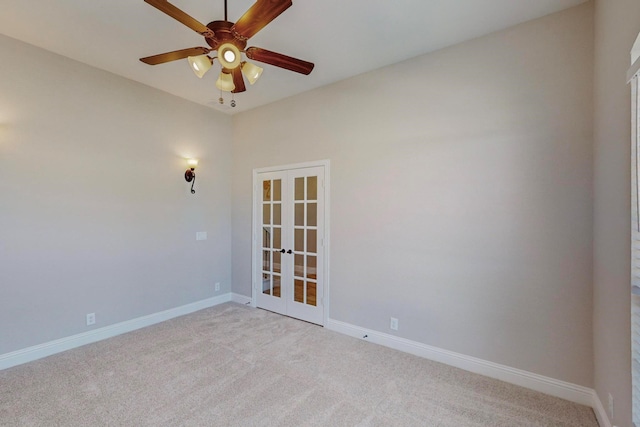 carpeted spare room featuring french doors and ceiling fan