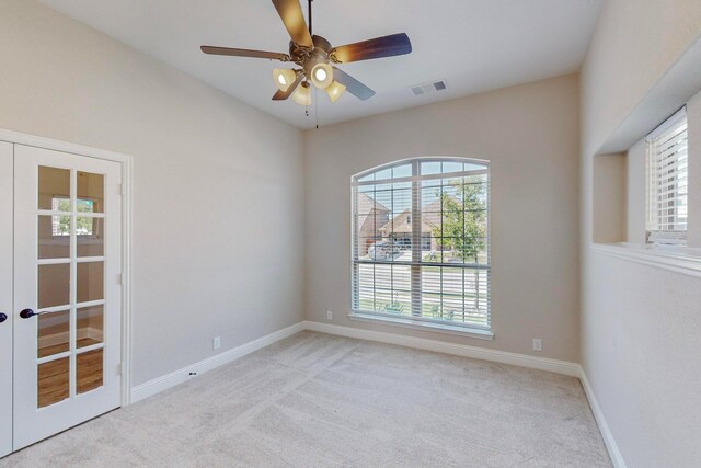 carpeted empty room featuring ceiling fan and french doors