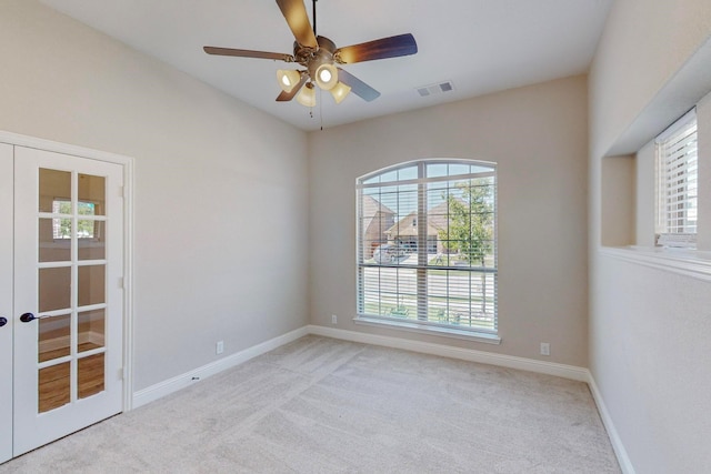 carpeted spare room with french doors and ceiling fan