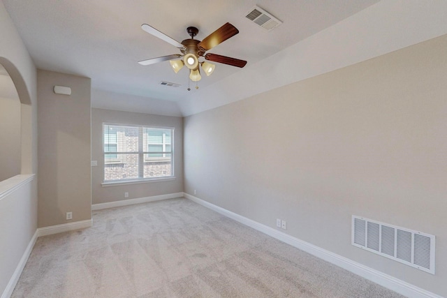 carpeted spare room with ceiling fan and vaulted ceiling