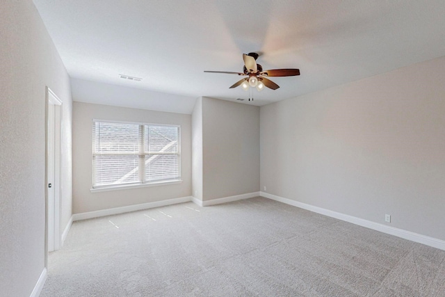 spare room featuring light carpet and ceiling fan