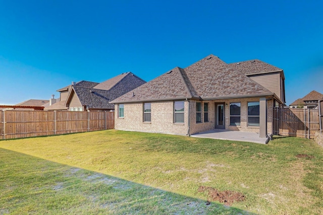 back of house featuring a lawn and a patio