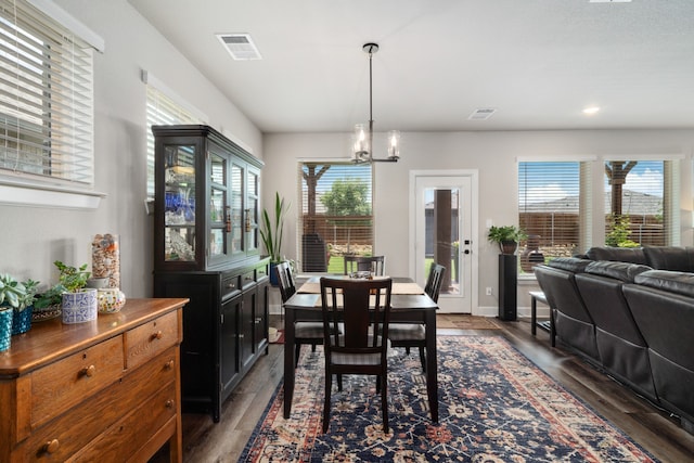 dining room featuring a notable chandelier and dark wood-type flooring