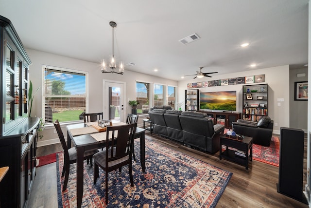 dining space featuring dark hardwood / wood-style flooring, ceiling fan with notable chandelier, and a healthy amount of sunlight