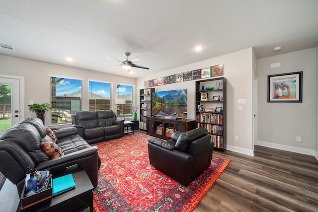 living room with ceiling fan and dark hardwood / wood-style flooring