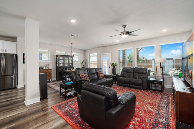 living room featuring dark hardwood / wood-style floors and ceiling fan with notable chandelier