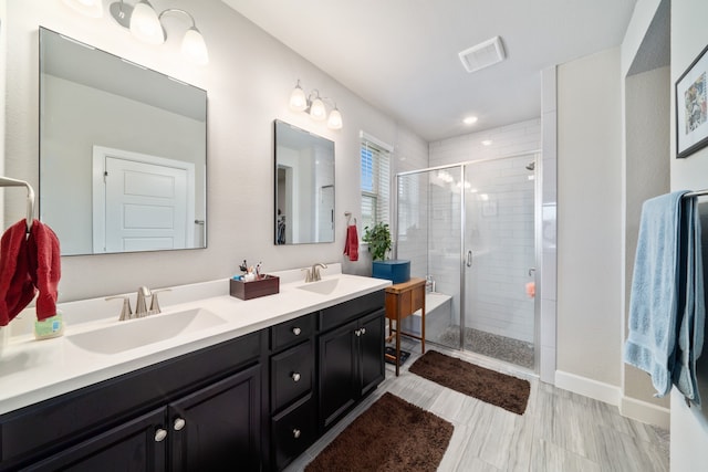 bathroom featuring vanity and a shower with shower door