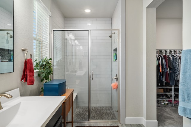 bathroom featuring vanity and a shower with door