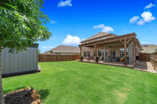 rear view of house featuring a storage unit, a patio area, and a yard