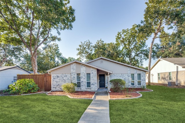 single story home featuring a front yard and central air condition unit