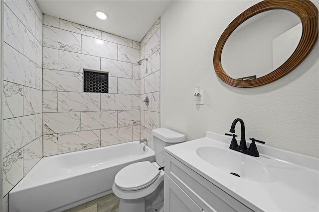 full bathroom with vanity, wood-type flooring, tiled shower / bath combo, and toilet