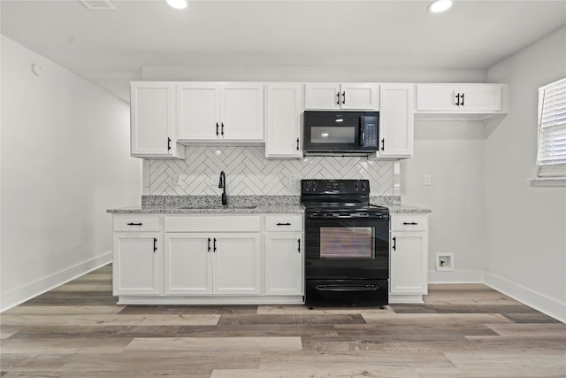 kitchen with sink, light stone counters, backsplash, white cabinets, and black appliances