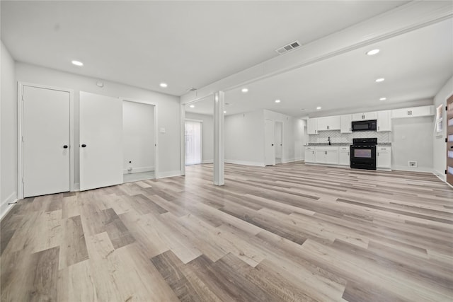 unfurnished living room featuring light hardwood / wood-style flooring and sink