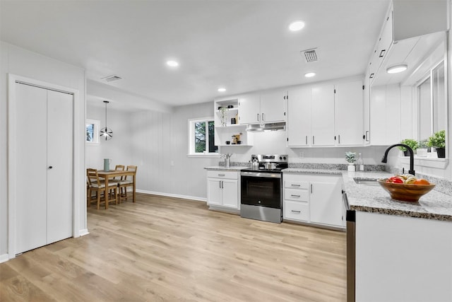 kitchen with white cabinets, light hardwood / wood-style floors, stainless steel electric range oven, light stone counters, and sink