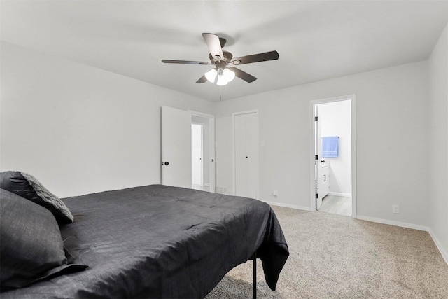 bedroom featuring ensuite bathroom, light colored carpet, and ceiling fan