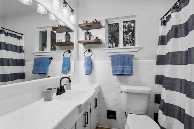 bathroom featuring tile walls, toilet, walk in shower, and vanity