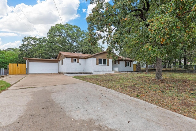 ranch-style house featuring a front yard and a garage