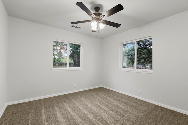 empty room featuring ceiling fan, carpet, and plenty of natural light