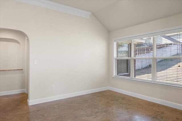 empty room with lofted ceiling, ornamental molding, and concrete flooring