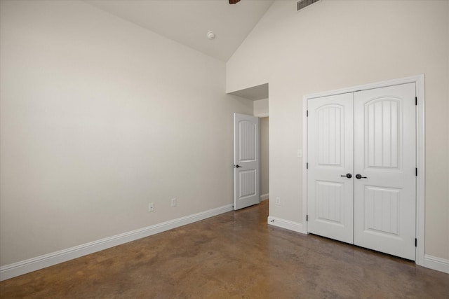 unfurnished bedroom featuring a closet and high vaulted ceiling